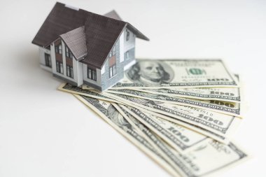 Bir sürü banknotu ve anahtarı olan küçük bir ev modeli. Emlak sigortası. Yatırım. Yüksek kalite fotoğraf