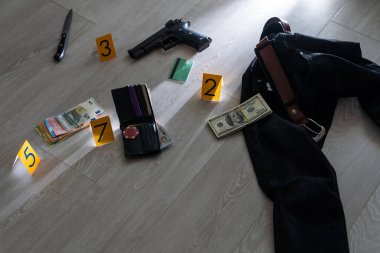 Olay yeri inceleme konsepti, tabanca ve mermi kovanına karşı apartmanın zeminindeki sarı işaret. Yüksek kalite fotoğraf