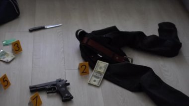 Olay yeri inceleme konsepti, tabanca ve mermi kovanına karşı apartmanın zeminindeki sarı işaret. Yüksek kalite fotoğraf