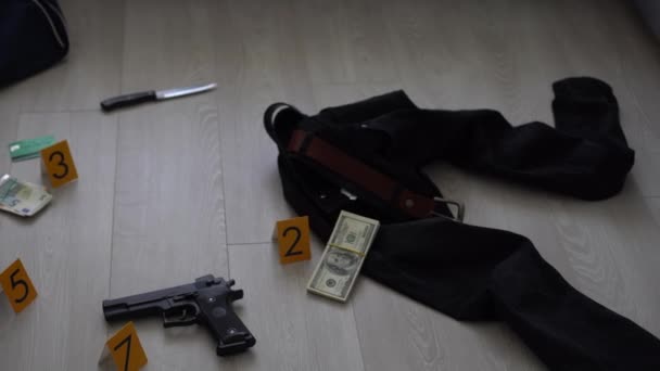 犯罪現場調査の概念 アパートの床に黄色の犯罪マーカーに対するピストルと弾丸の殻 高品質の写真 — ストック動画