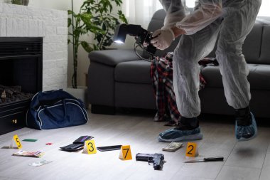 Adli tıp bir cinayet mahallinde kan lekeli bir bıçağı fotoğraflıyor. Yüksek kalite fotoğraf