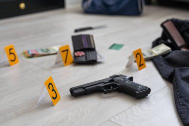 Olay yeri inceleme konsepti, tabanca ve mermi kovanına karşı apartmanın zeminindeki sarı işaret. Yüksek kalite fotoğraf