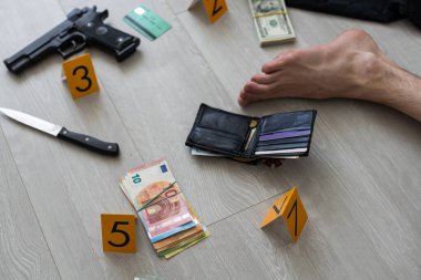 Kurbanın eli kanıt işaretleri ve apartman dairesinin zemininde bulunan eşyalarla çevrili. Olay yeri inceleme ve belgelendirme süreci. Yüksek kalite fotoğraf