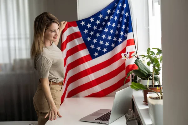 Amerikan Bayrağıyla Dizüstü Bilgisayar Kullanan Mutlu Genç Bir Bayan Resmi — Stok fotoğraf