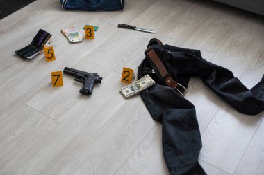 Olay yeri inceleme konsepti, tabanca ve mermi kovanına karşı apartmanın zeminindeki sarı işaret. Yüksek kalite fotoğraf