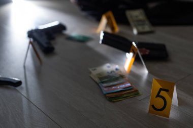 Olay yeri inceleme konsepti, tabanca ve mermi kovanına karşı apartmanın zeminindeki sarı işaret. Yüksek kalite fotoğraf