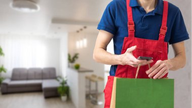 Elinde kağıt torba tutan yakışıklı bir genç..