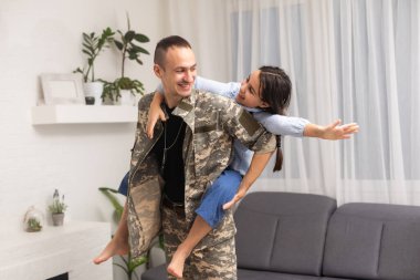 Sevgi kız babası kamuflaj ve geri dışarı kamera bakıyor.