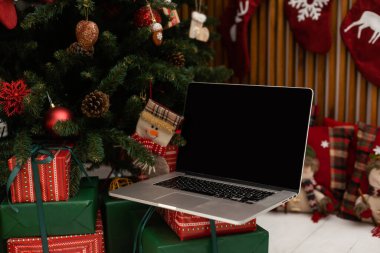 Hediyeli dizüstü bilgisayar, arkada Noel ağacı..