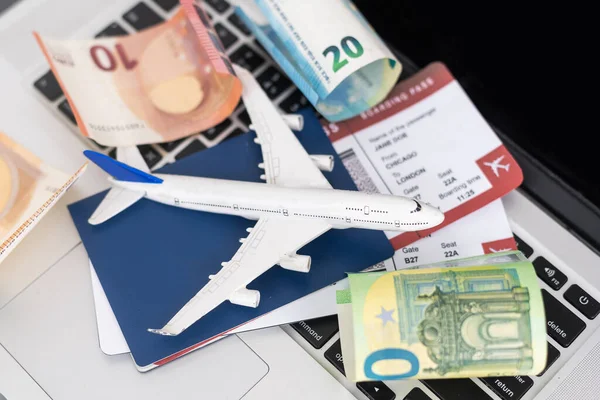 Composition with laptop, toy plane, money and passport on map. Travel agency and ticket booking concept