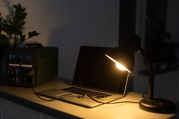 stock image Portable power station charging gadgets near wall.