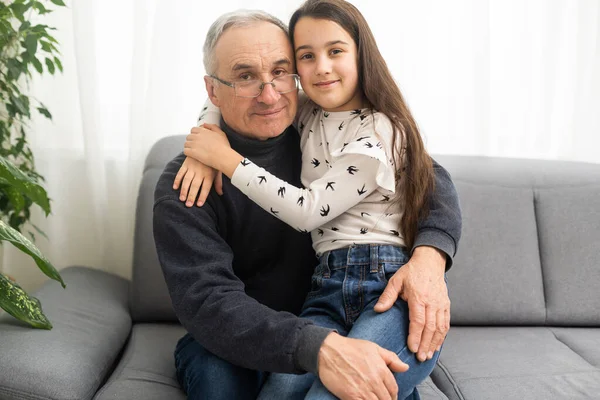Smiling Granddad Hugging Girl While Sitting Sofa — Stock Photo, Image