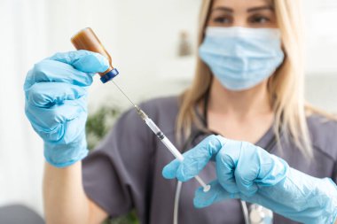 Araştırmacıların ellerinde COVID-19 aşısı, kadın doktorlar Coronavirus tedavisi için şırınga ve şişe tutuyorlar. Salgın sırasında korona virüsü tedavisi, enjeksiyon, iğne ve klinik deney kavramı