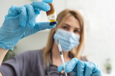 Araştırmacıların ellerinde COVID-19 aşısı, kadın doktorlar Coronavirus tedavisi için şırınga ve şişe tutuyorlar. Salgın sırasında korona virüsü tedavisi, enjeksiyon, iğne ve klinik deney kavramı
