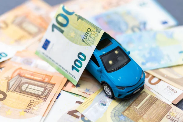 model car on banknotes, symbolic photo for car buying, financing and costs. High quality photo