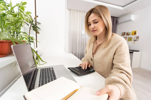 노트북으로 일하는 집중적 여성의 사진은 집중적 주부들 컴퓨터의 청구서 세금등을 — 스톡 사진
