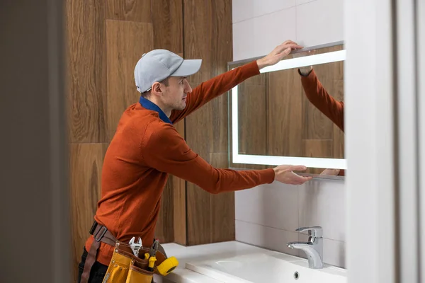 Der Arbeiter Montiert Den Spiegel Badezimmer — Stockfoto