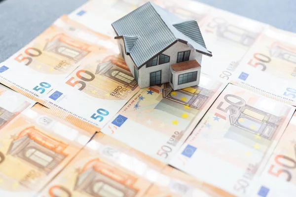 Buying and building a house.House and money. Real estate market. house with gray roof on euro banknotes background. . High quality photo