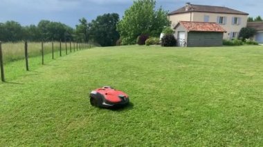 Parkta otonom çim biçme makinesi. Kırmızı robotik otomatik çim biçme makinesi. Yüksek kalite 4k görüntü