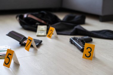 Olay yeri inceleme konsepti, tabanca ve mermi kovanına karşı apartmanın zeminindeki sarı işaret. Yüksek kalite fotoğraf