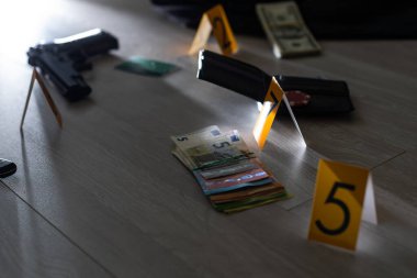 Olay yeri inceleme, dairedeki cinayetten sonra kanıtların numaralandırılması. Pirinç muşta, cüzdan ve üzerinde kanıt işaretleri olan kıyafetler. Yüksek kalite fotoğraf