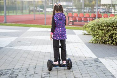 Küçük kız Segway 'e biniyor ve hafta sonu eğleniyor.