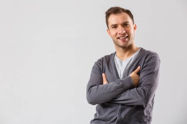 Confident and stylish. young man and looking at camera while standing against white background.