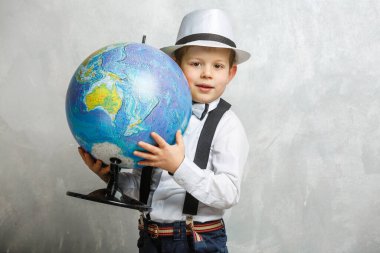 Sevimli beyaz bir öğrenci ilkokulun sınıfında oturuyor. Globe 'un yanındaki küçük çocuk. Okul konseptine dönelim..