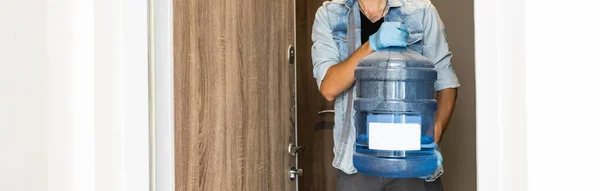 stock image Delivery water man wear protective face medical mask during coronavirus pandemia.