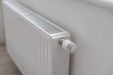 Radyatörlü beyaz ısıtıcı ve bir apartmanın duvarında modern bir termostat. Yüksek kalite fotoğraf