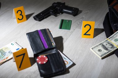 Olay yeri inceleme konsepti, tabanca ve mermi kovanına karşı apartmanın zeminindeki sarı işaret. Yüksek kalite fotoğraf