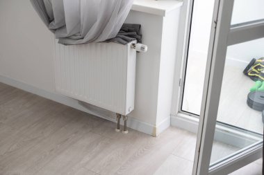 Radyatörlü beyaz ısıtıcı ve bir apartmanın duvarında modern bir termostat. Yüksek kalite fotoğraf