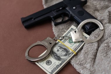 Kelepçe, dolar, parmak izi susturuculu bir silah, tahta bir arka planda uyuşturucu. Bir suçluyu tutuklamak, uyuşturucu ticareti. Yüksek kalite fotoğraf