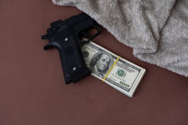 Amerikan dolarlarının üzerindeki tabanca - suçlu para konsepti. Yüksek kalite fotoğraf
