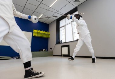 İki kız eskrim sporcusu profesyonel spor sahasında kavga ediyor. Yüksek kalite fotoğraf