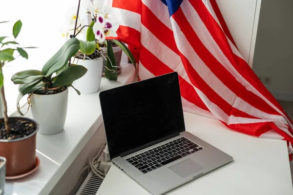US flag and laptop on white background with copy space. High quality photo