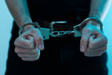 Demir hapishaneyi, mahkum konseptini hapisteki bir mahkumun ellerini kelepçelemek isteyen genç bir adam, erkek mahkumlar karanlık bir hapishanede şiddetli bir şekilde zorlandılar, şiddet, şiddet. Yüksek kalite fotoğraf