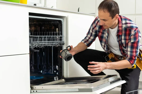 家電メンテナンス 汚れた食器洗い機の食品残留物フィルターを除去する便利屋 高品質の写真 — ストック写真