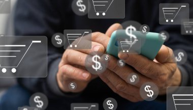 Çevrimiçi alışveriş ve e-ticaret kavramı. Genç adam alışveriş arabası simgesi olan dizüstü bilgisayarı kullanıyor, çevrimiçi mağazada sipariş veriyor, internetten alışveriş yapıyor, klavyede el yazısı olan sanal ekranda konsept kullanıyor.