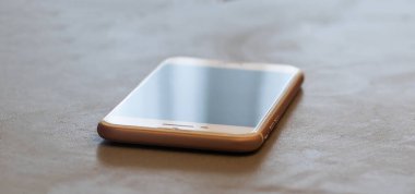 A single mobile phone on table in the office.