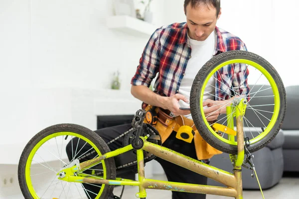 Joven Reparando Bicicleta Casa Foto Alta Calidad — Foto de Stock