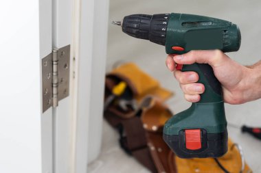 Çilingir marangoz, ev hizmeti tazminatı için beyaz kapı tokmağını tornavidayla tamir etti. Yüksek kalite fotoğraf