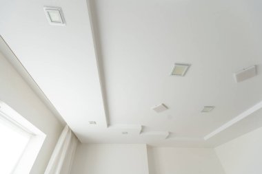 Klasik beyaz parlak tavan, sönük spot ışıklarıyla. Yüksek kalite fotoğraf