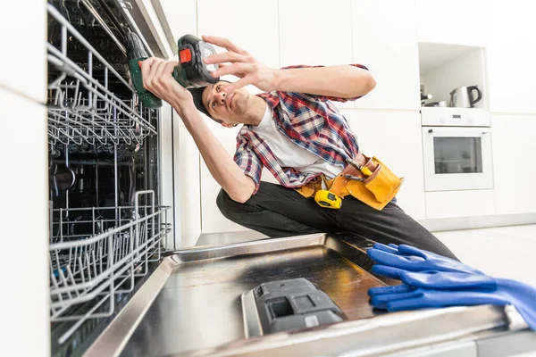 自宅のストックフォトで食器洗い機を修復するためにドライバーを使用して労働者 高品質の写真 — ストック写真