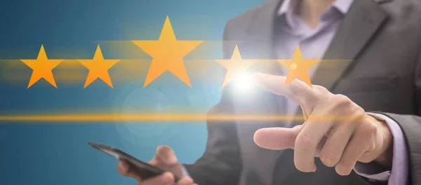 Stock image Young businessman ranking with his hand using digital stars. High quality photo