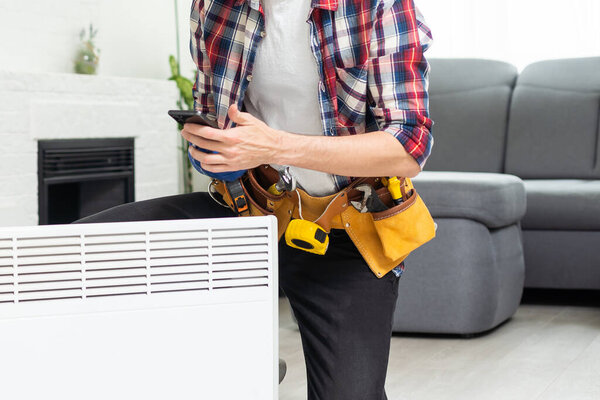 service man with wrench near radiator. High quality photo
