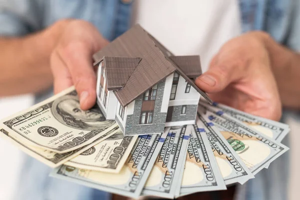 stock image Business people hold banknotes with gray roof houses in banknotes Real estate investment ideas, mortgages, saving money for new homes, home loans with space for entering text. High quality photo