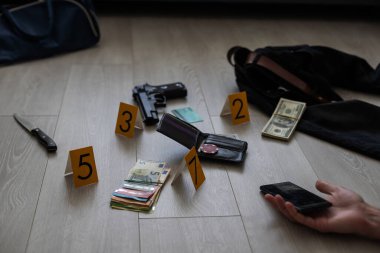 Yerde bir ceset ve silahla kanlı bir suç mahallinin yüksek kontrastlı görüntüsü. Yüksek kalite fotoğraf