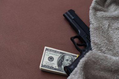 Bir yığın Amerikan doları ve siyah bir tabanca. Yukarıdan görüldü. Yüksek kalite fotoğraf