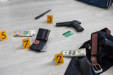 Olay yeri inceleme konsepti, tabanca ve mermi kovanına karşı apartmanın zeminindeki sarı işaret. Yüksek kalite fotoğraf